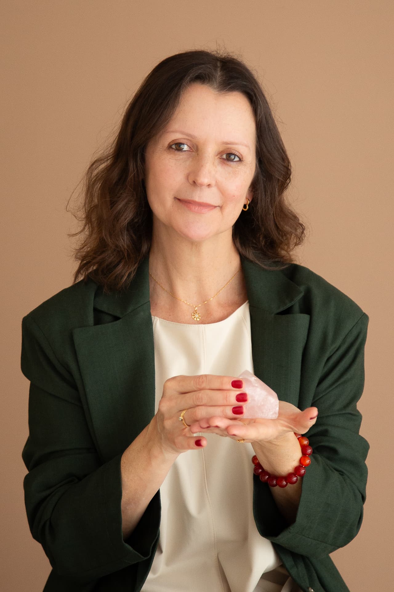 Retrato de Luciane Oliveira Dias segurando um cristal de quartzo rosa